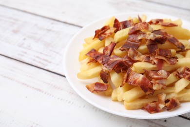 Photo of Delicious French fries with bacon on wooden rustic table, closeup. Space for text