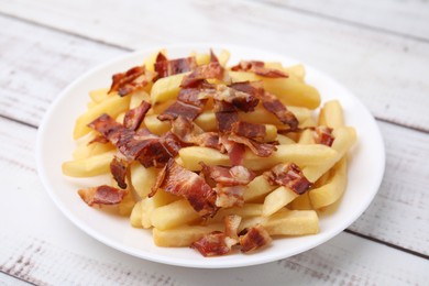 Photo of Delicious French fries with slices of bacon on wooden rustic table, closeup