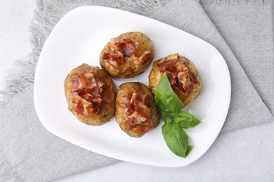 Photo of Delicious baked potatoes with bacon and basil on grey table, top view