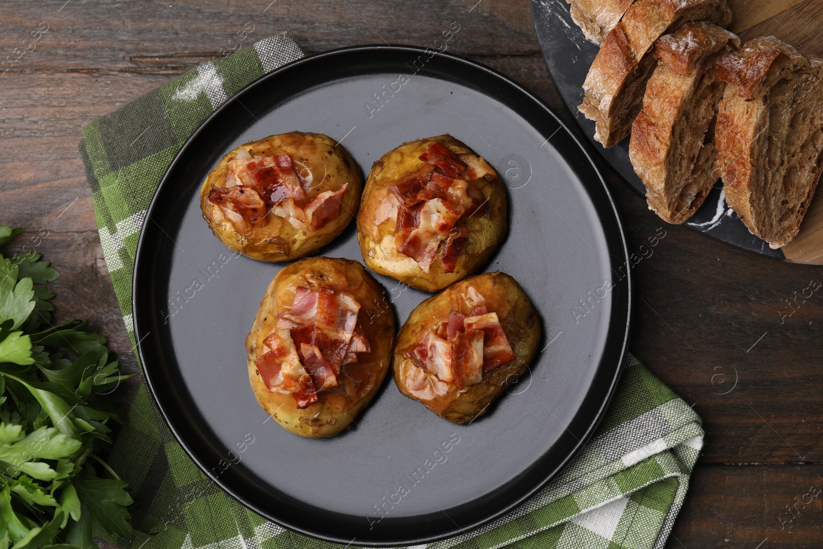 Photo of Delicious baked potatoes with bacon on wooden table, flat lay