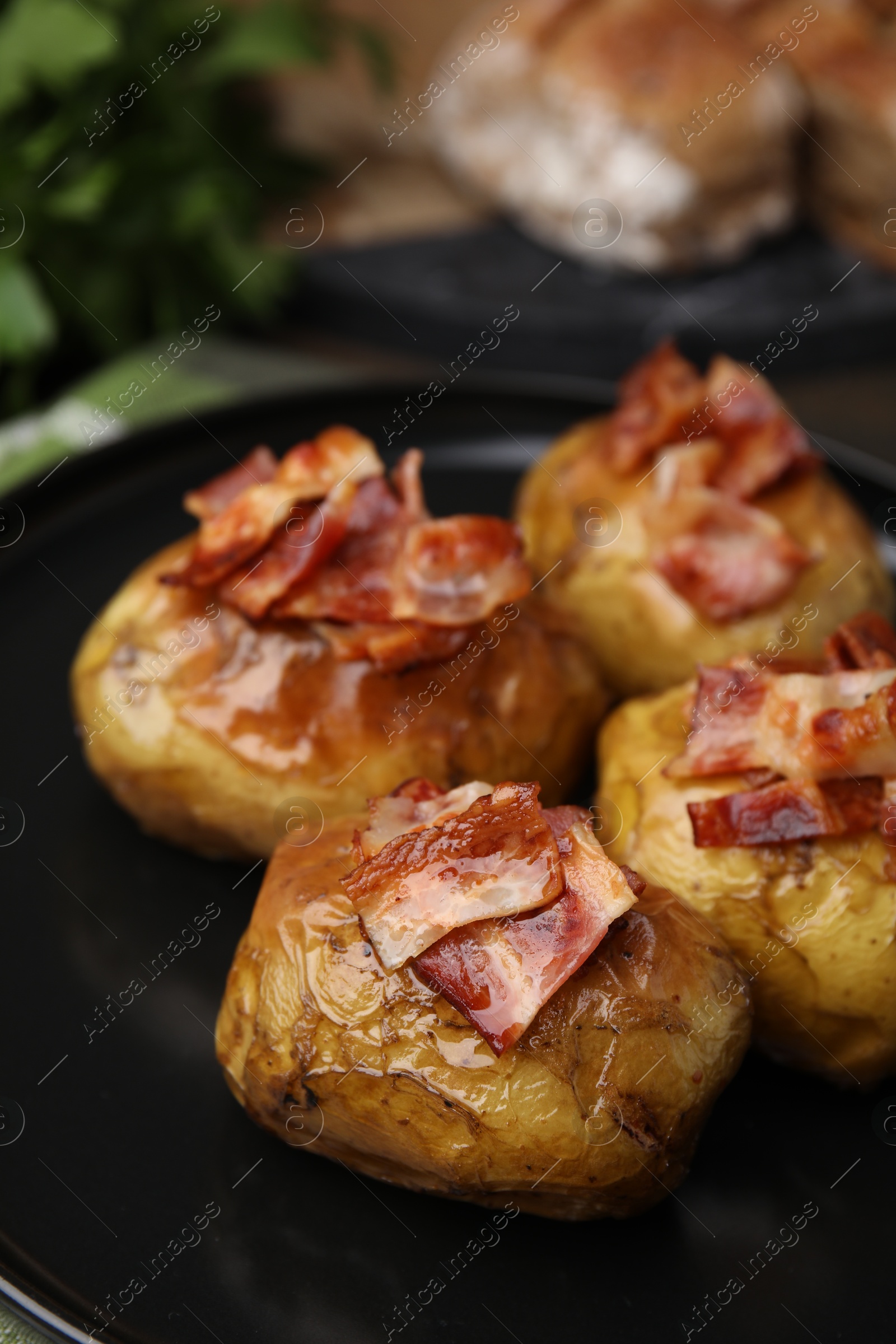 Photo of Delicious baked potatoes with bacon on table, closeup