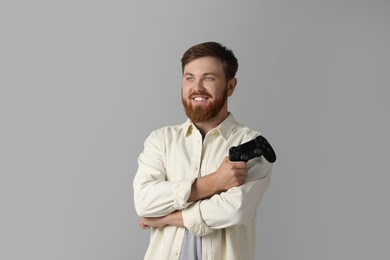 Photo of Smiling man with game controller on grey background