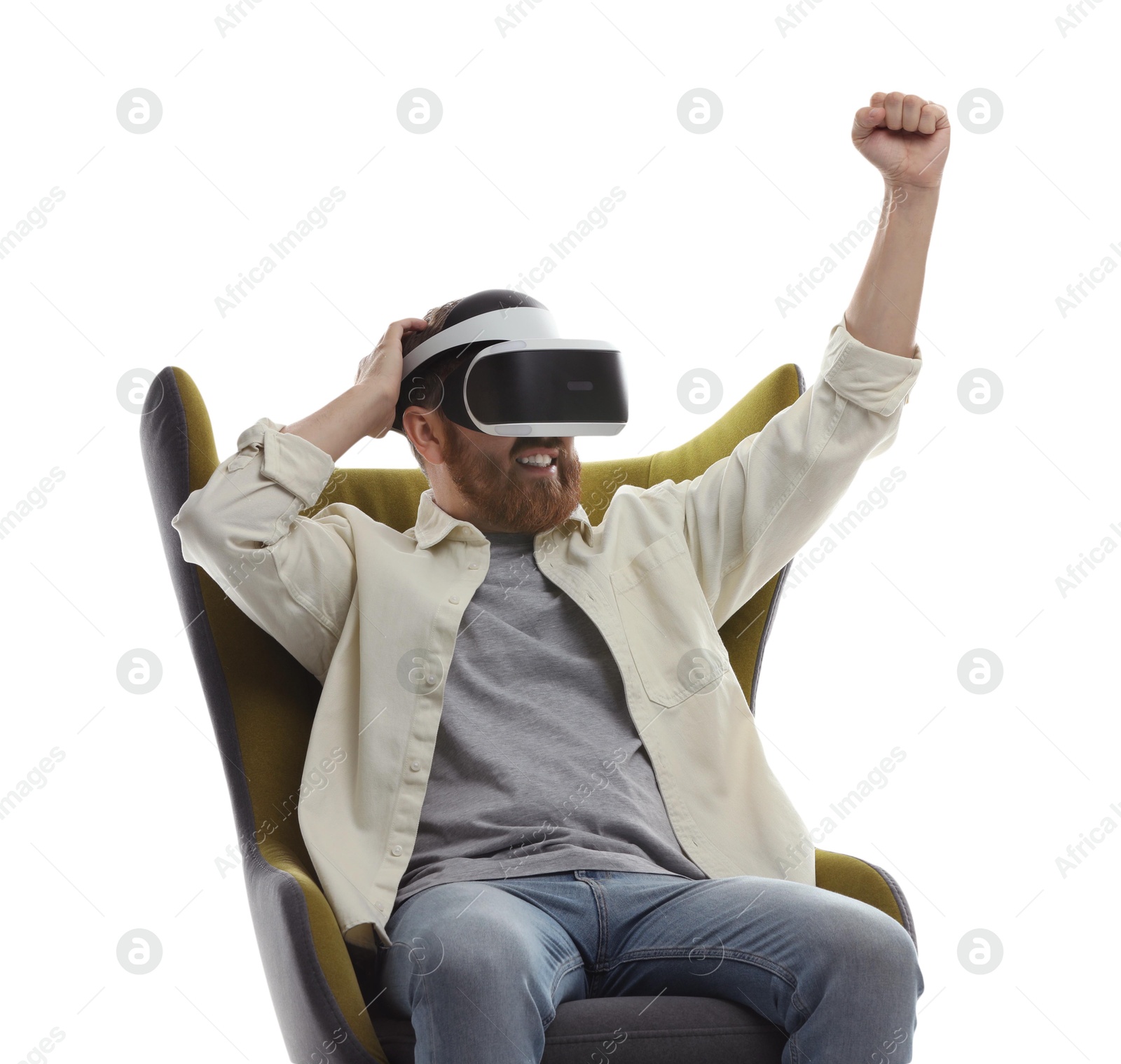 Photo of Smiling man using virtual reality headset while sitting in armchair on white background