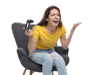 Emotional woman with game controller sitting in armchair on white background