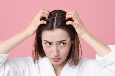 Young woman with hair loss problem on pink background