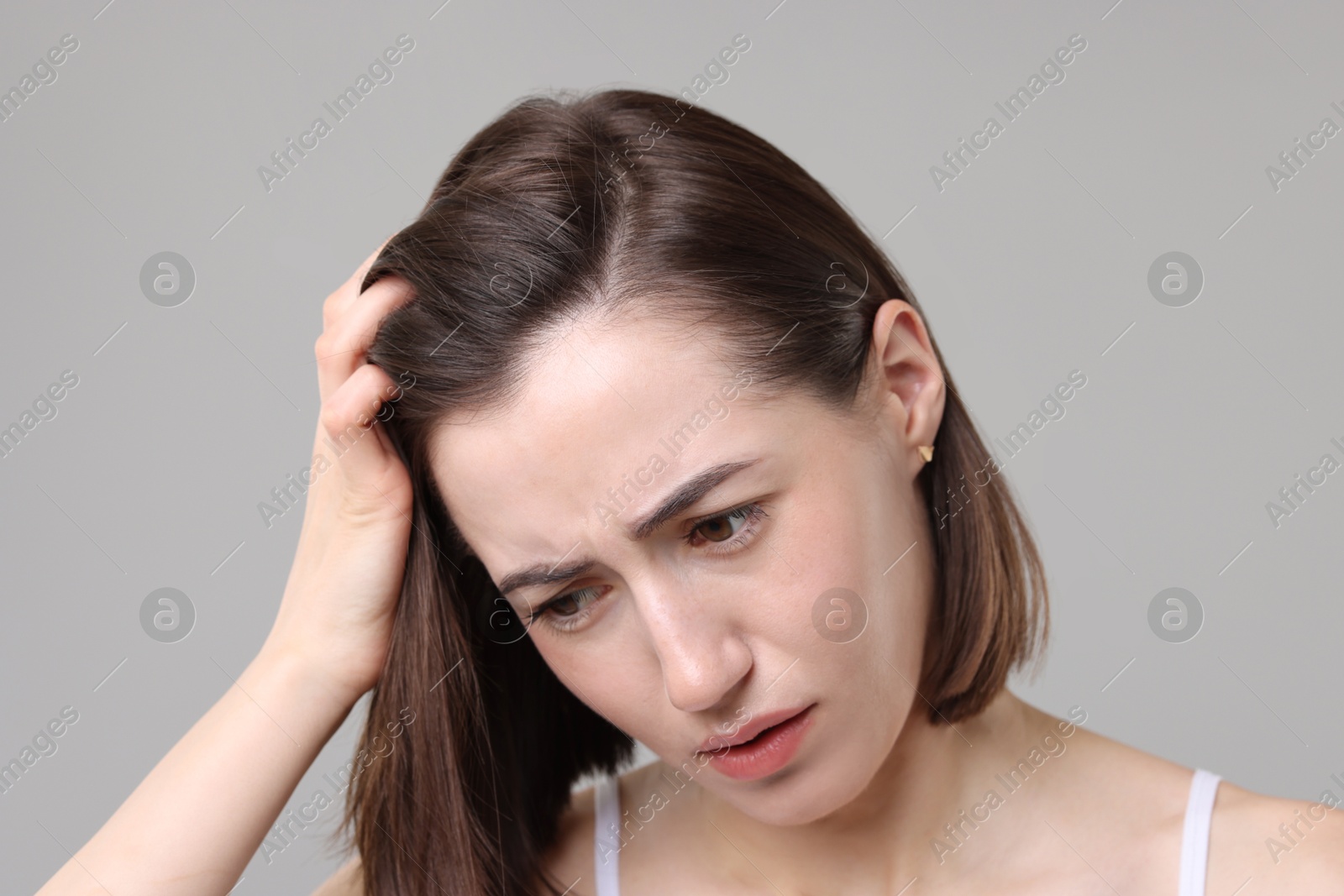 Photo of Sad woman with hair loss problem on grey background