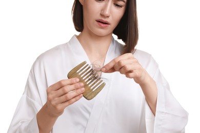 Woman taking her lost hair from comb on white background, closeup. Alopecia problem