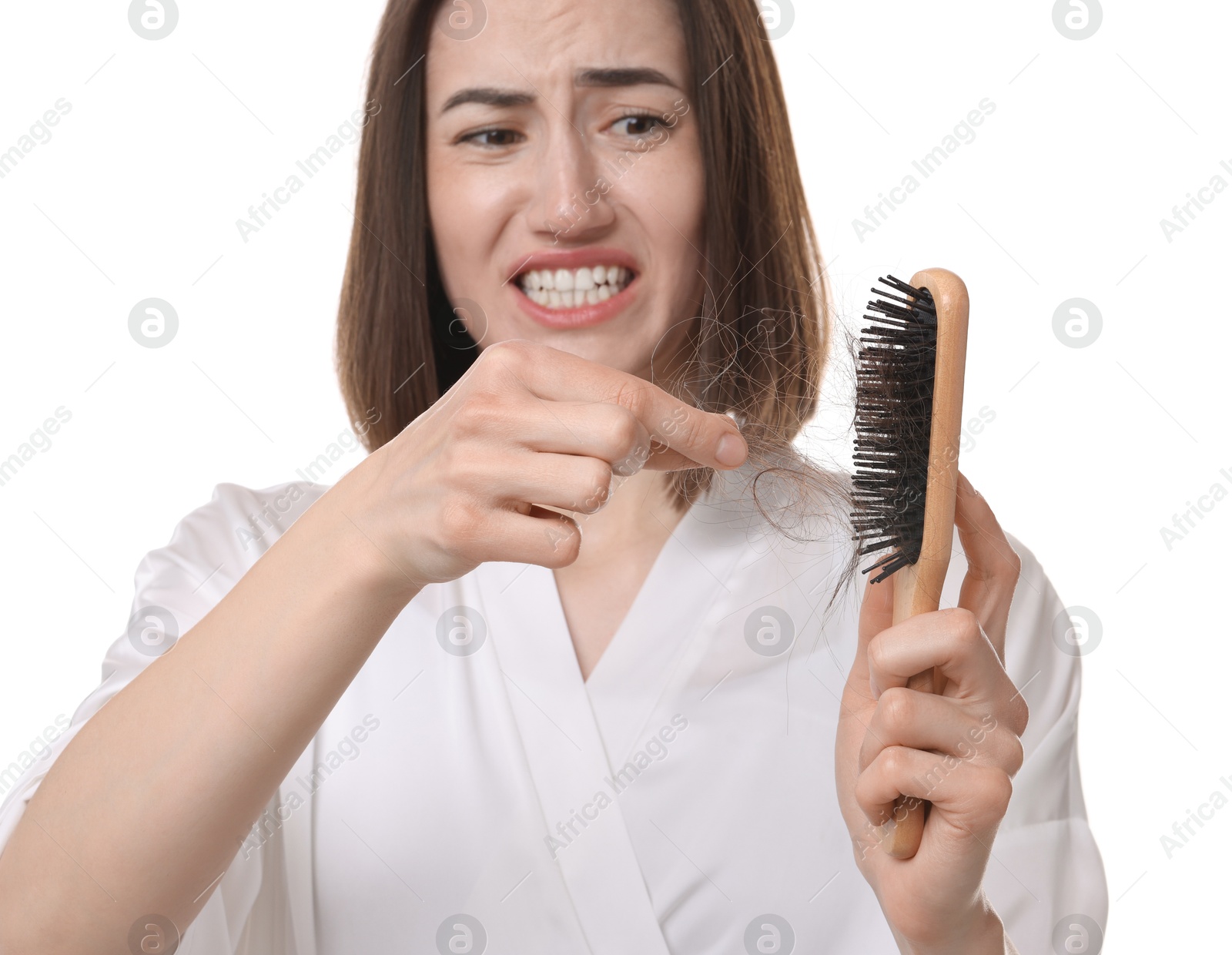 Photo of Emotional woman taking her lost hair from brush on white background. Alopecia problem