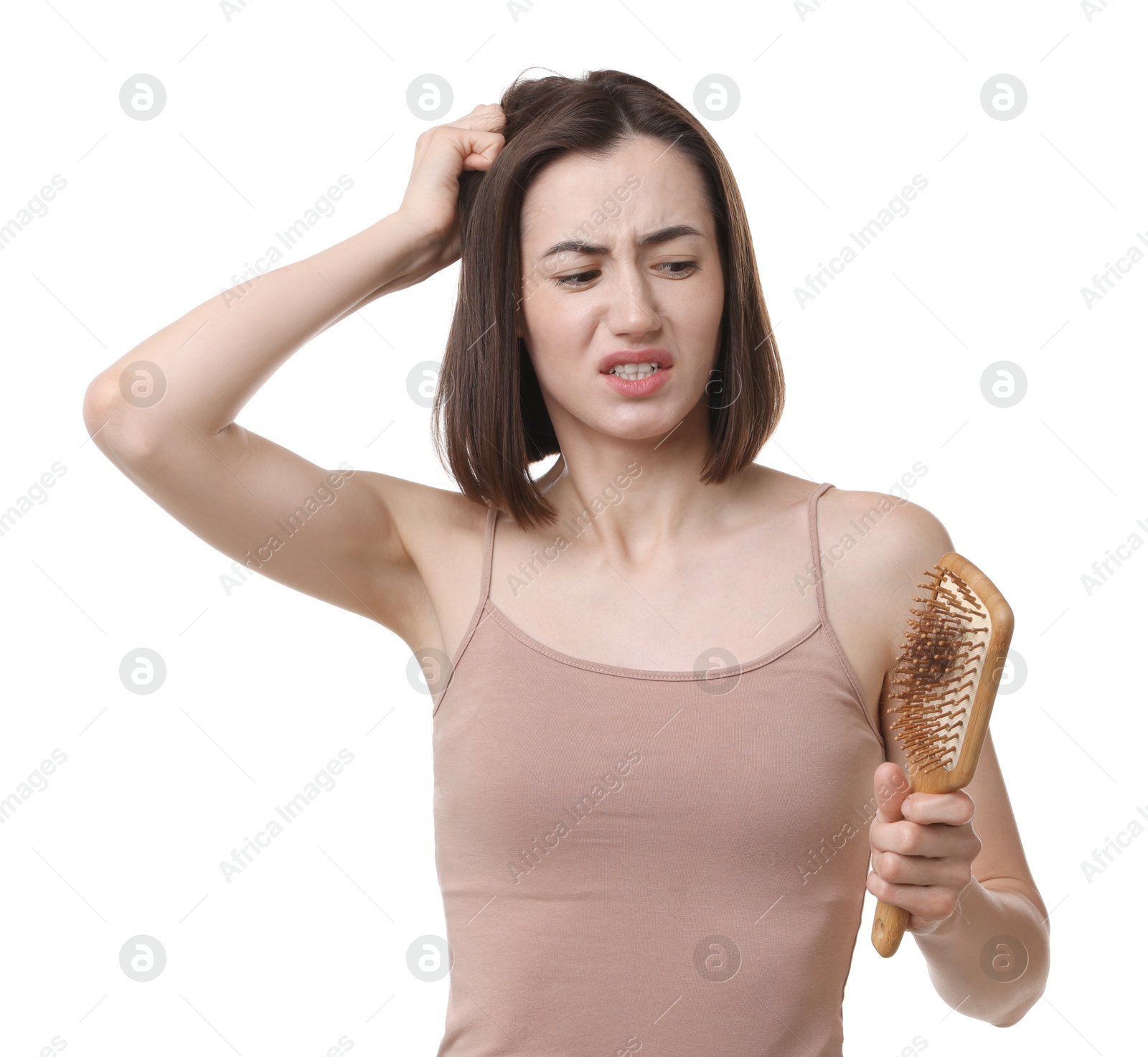 Photo of Emotional woman holding brush with lost hair on white background. Alopecia problem