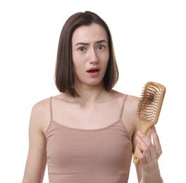 Photo of Emotional woman holding brush with lost hair on white background. Alopecia problem