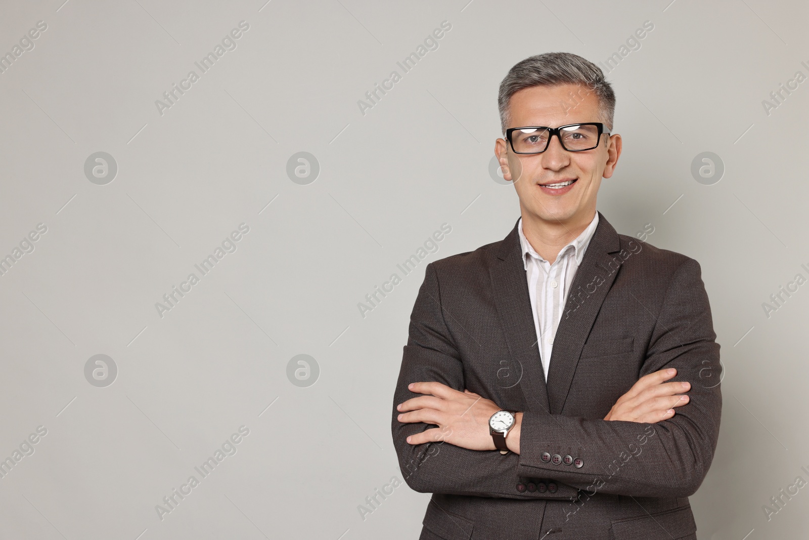 Photo of Happy man in glasses on grey background, space for text