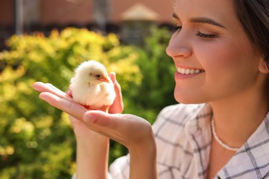 Woman with cute chick outdoors. Baby animal
