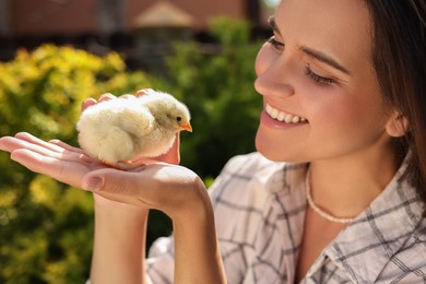Photo of Woman with cute chick outdoors. Baby animal