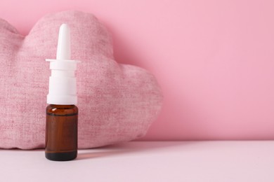 Photo of Cloud shaped pillow and nasal spray on color background, space for text