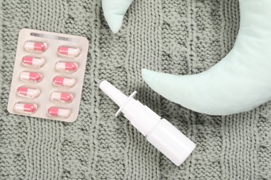 Pillow, pills and nasal spray on blanket, flat lay