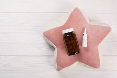 Pillow, pills and nasal spray on white wooden background, top view. Space for text