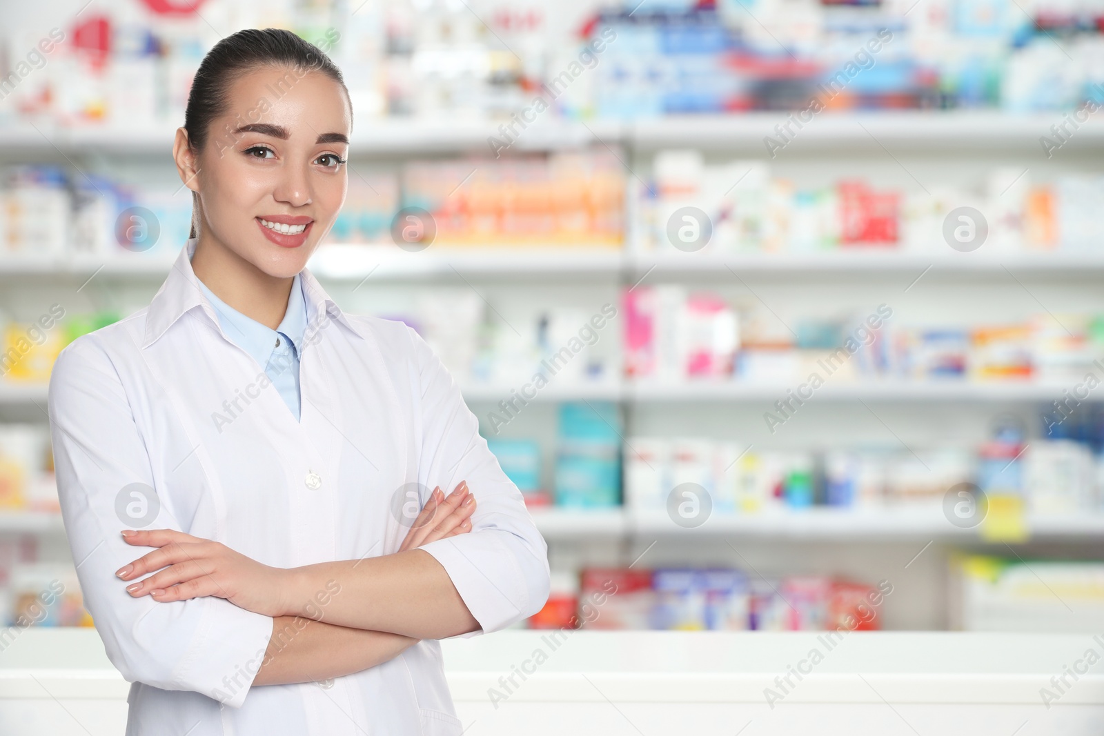 Image of Positive pharmacist in uniform at drugstore. Space for text