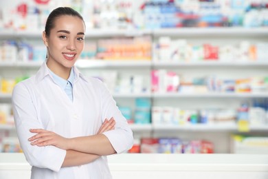 Positive pharmacist in uniform at drugstore. Space for text