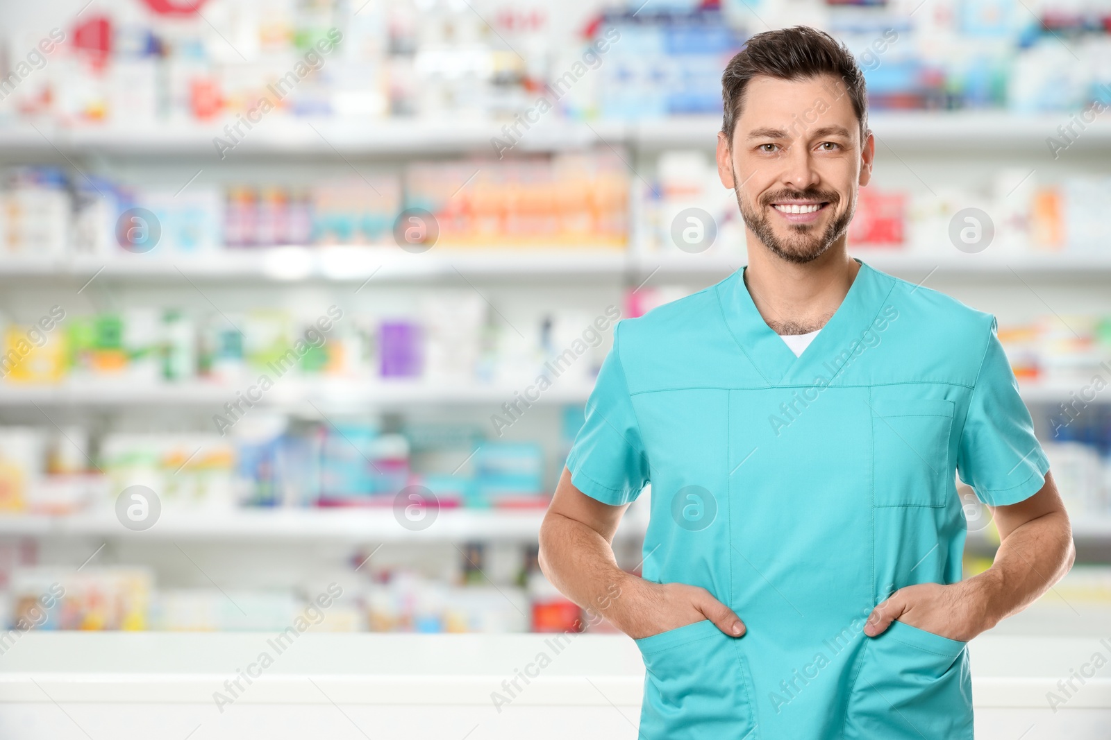 Image of Positive pharmacist in uniform at drugstore. Space for text