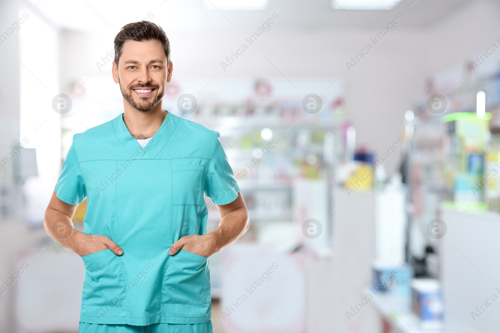 Image of Positive pharmacist in uniform at drugstore. Space for text