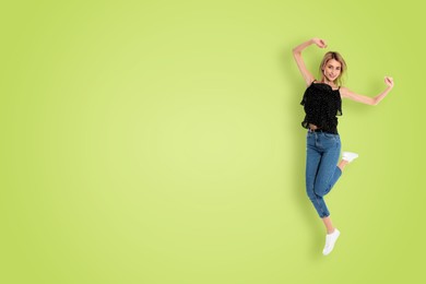 Positive young woman jumping on light green background. Space for text