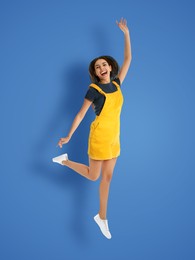 Image of Positive young woman jumping on blue background
