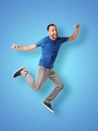 Image of Positive young man jumping on light blue background