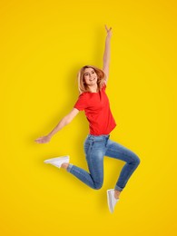 Image of Positive young woman jumping on yellow background