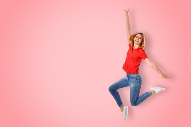 Image of Positive young woman jumping on pink background. Space for text