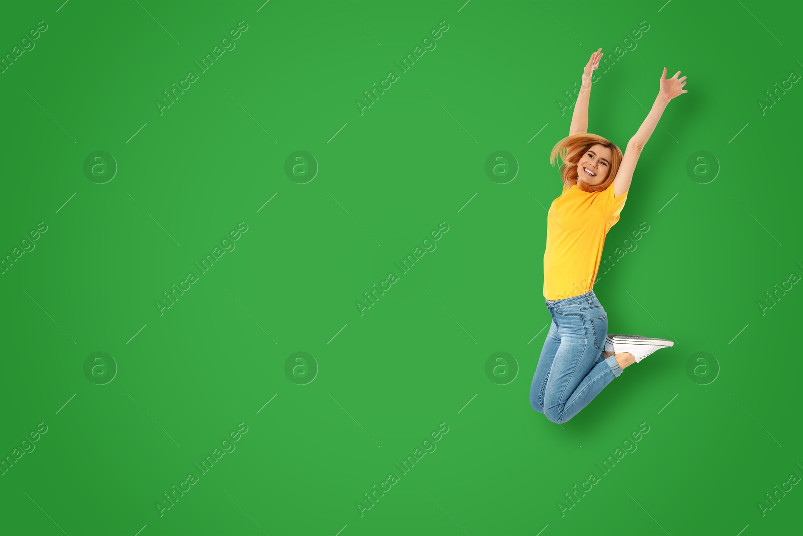 Image of Positive woman jumping on green background. Space for text