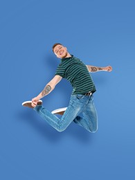 Image of Positive young man jumping on blue background