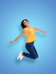 Image of Positive young woman jumping on light blue background