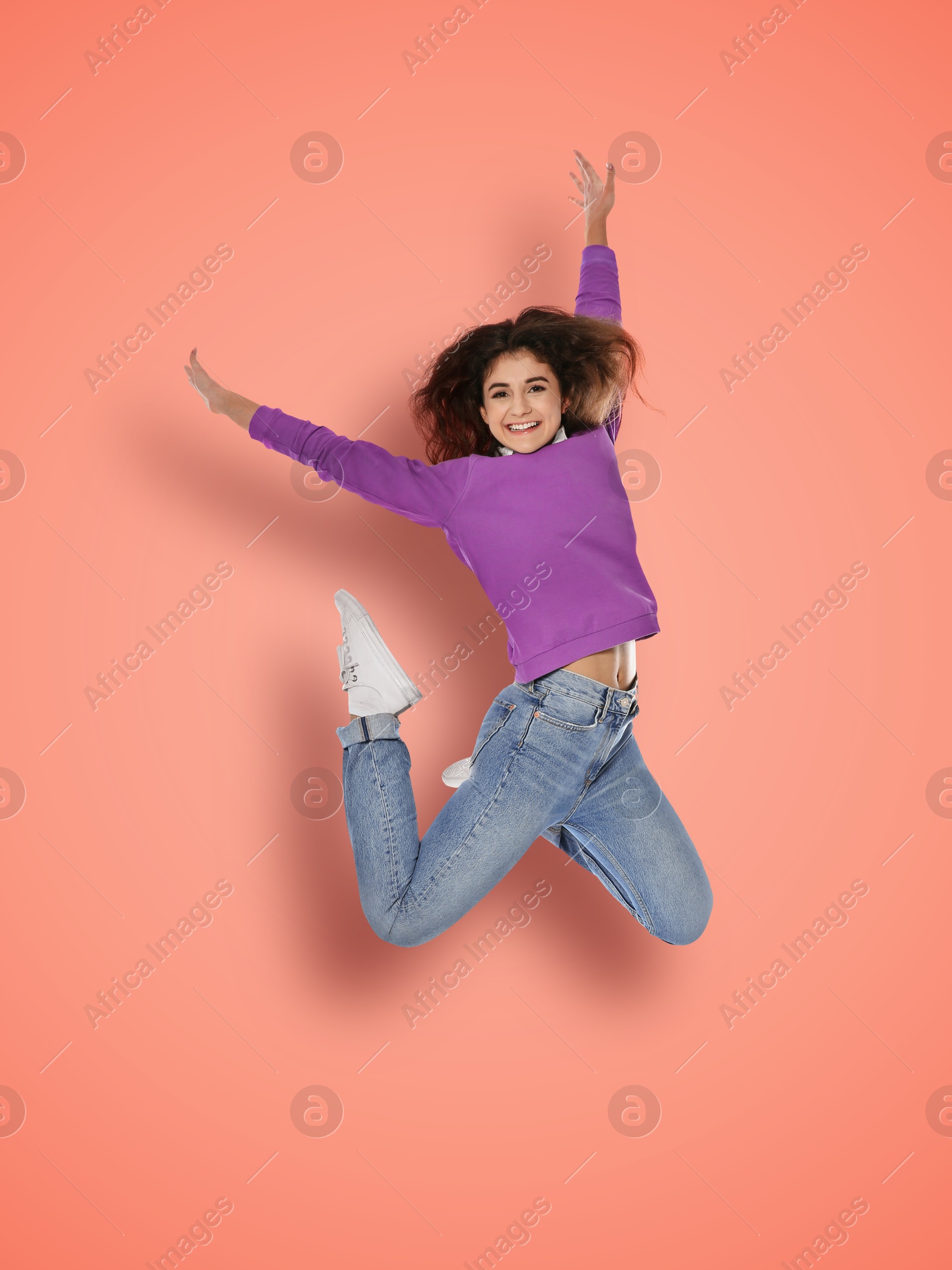 Image of Positive young woman jumping on pink background