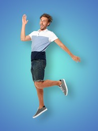 Image of Positive young man jumping on blue gradient background