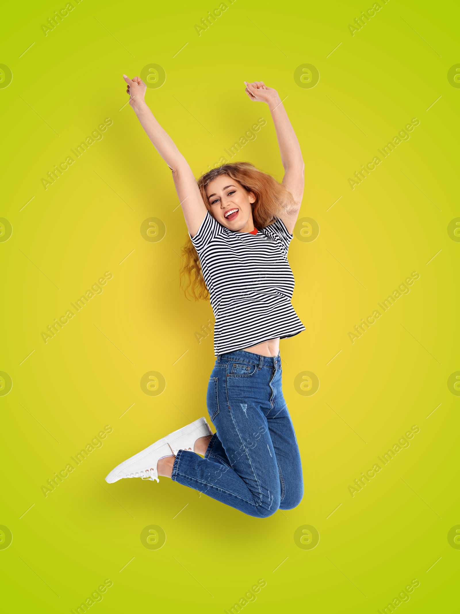 Image of Positive young woman jumping on yellow green gradient background