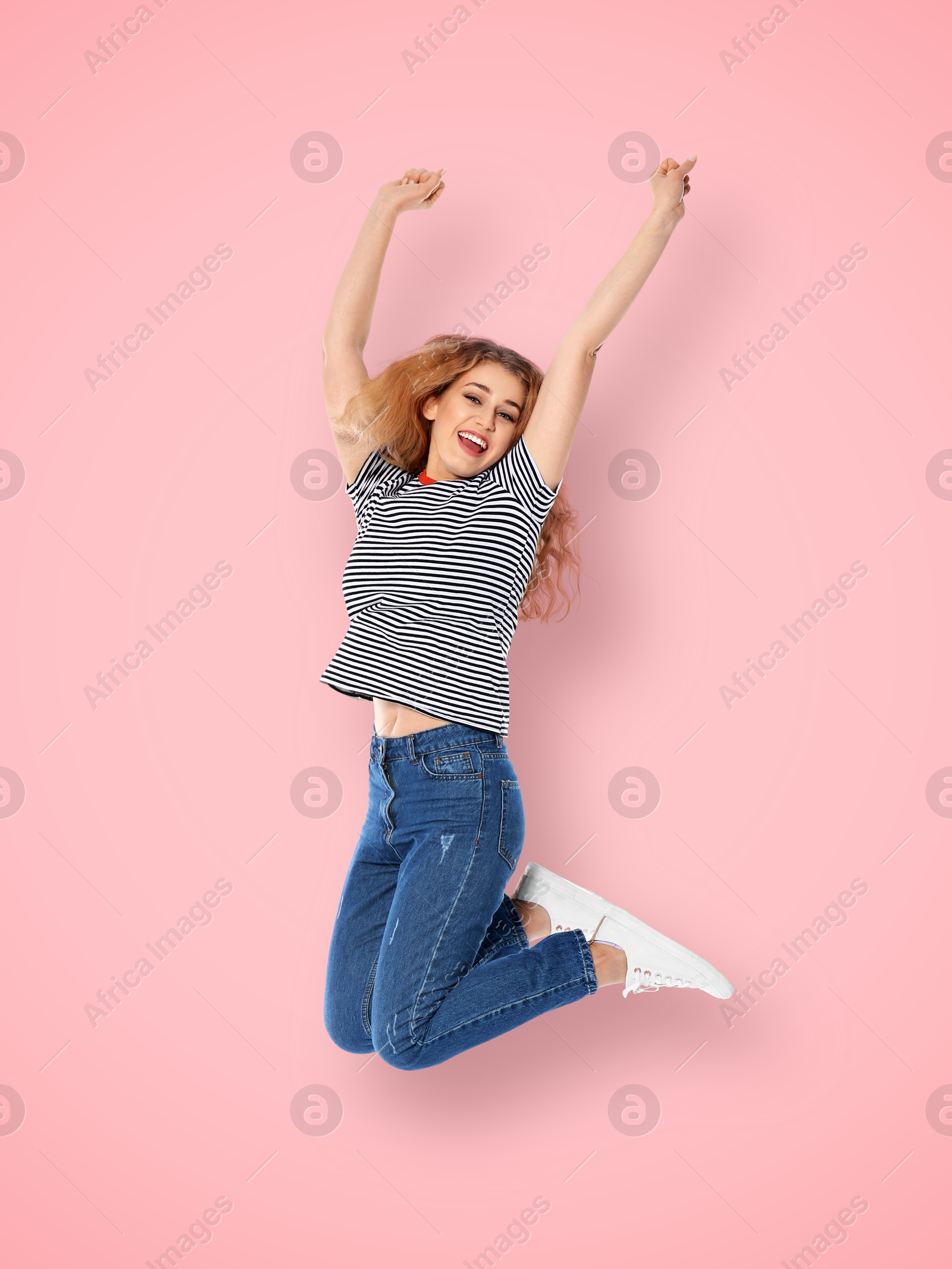 Image of Positive young woman jumping on pink background