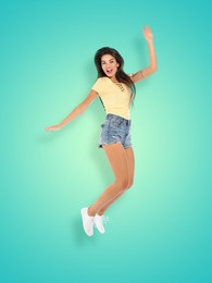 Image of Positive young woman jumping on turquoise gradient background
