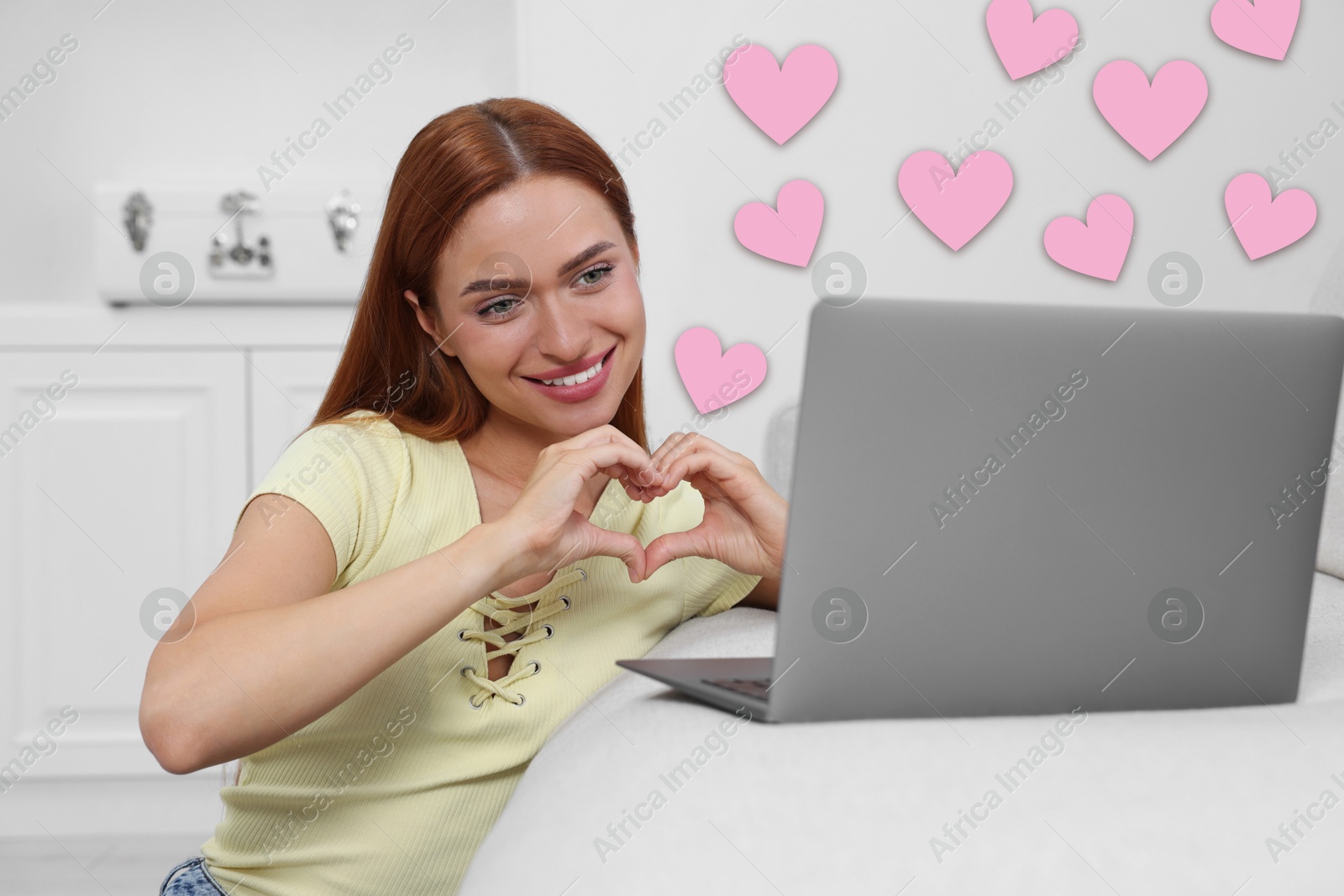 Image of Long distance relationship. Young woman having video chat with her loved one indoors. Pink hearts near her
