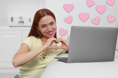 Long distance relationship. Young woman having video chat with her loved one indoors. Pink hearts near her