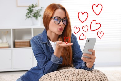 Long distance relationship. Young woman sending air kiss to her loved one via video chat indoors. Red hearts near her