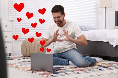 Image of Long distance relationship. Man having video chat with his loved one indoors. Red hearts near him