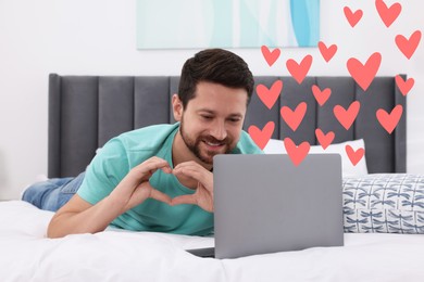 Image of Long distance relationship. Man having video chat with his loved one indoors. Pink hearts near him