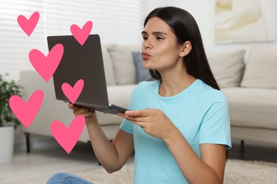 Long distance relationship. Young woman sending air kiss to her loved one via video chat indoors. Pink hearts near her