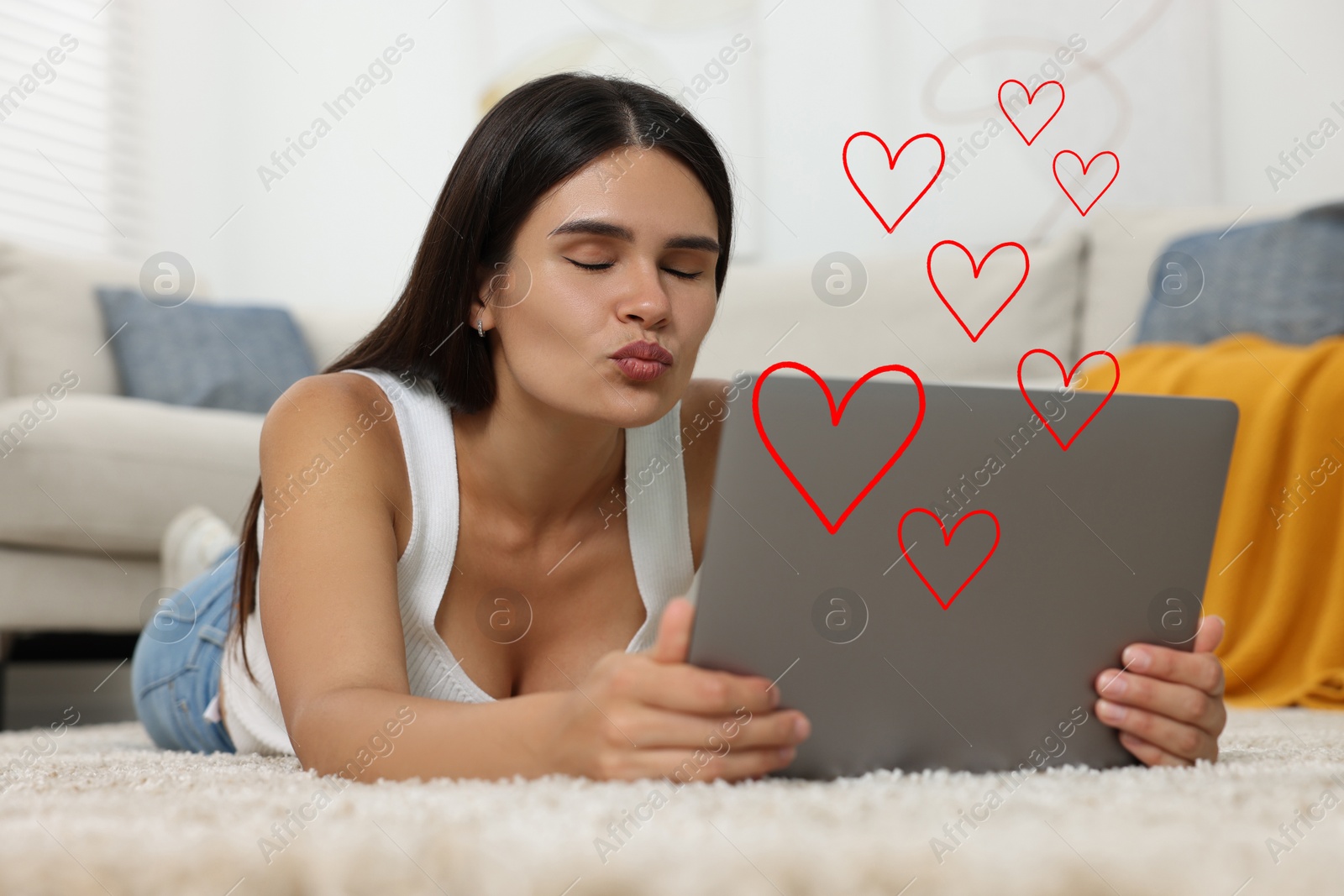 Image of Long distance relationship. Young woman sending air kiss to her loved one via video chat indoors. Red hearts near her