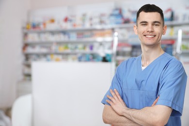 Positive pharmacist in uniform at drugstore. Space for text