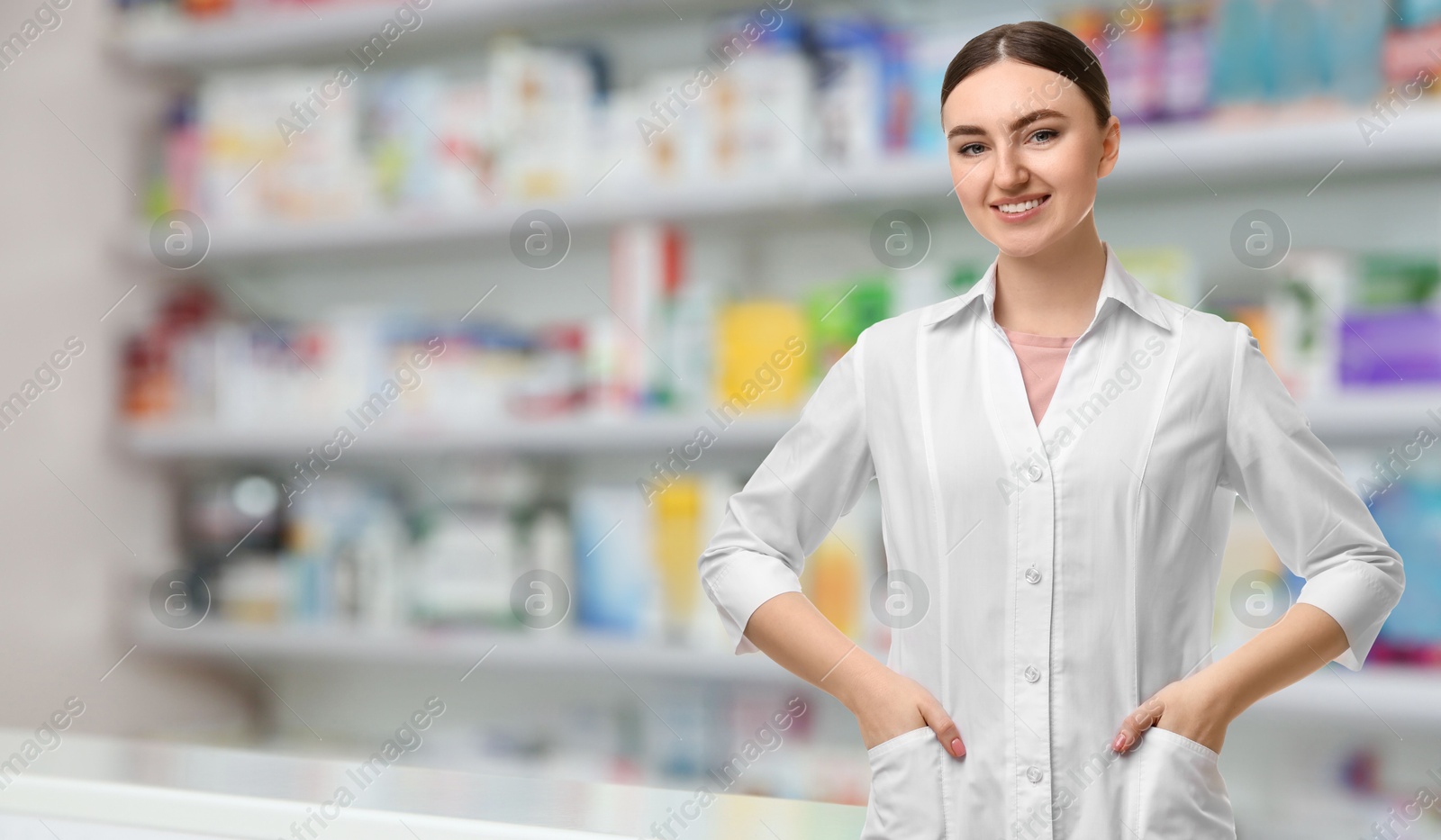 Image of Positive pharmacist in uniform at drugstore. Space for text