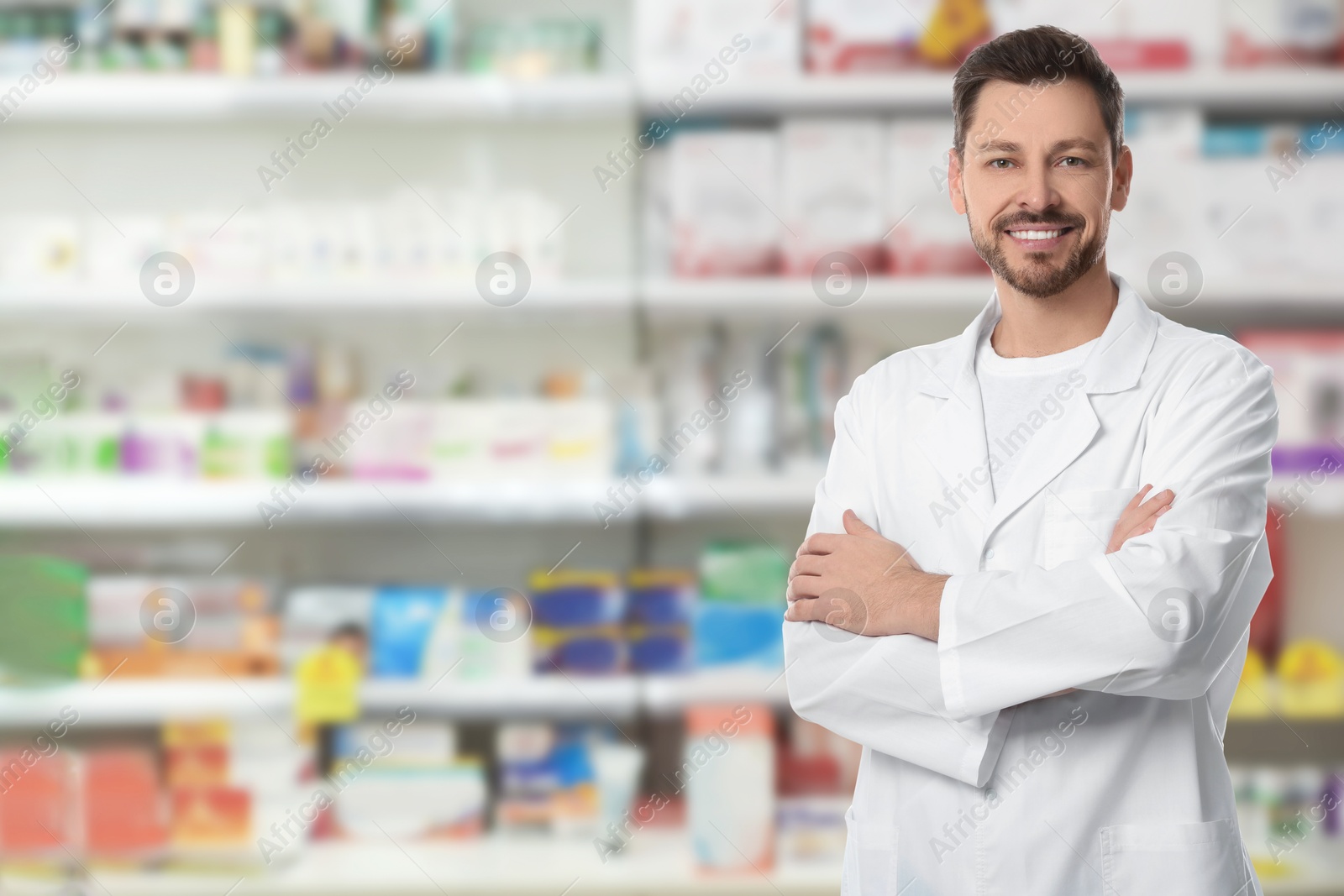 Image of Positive pharmacist in uniform at drugstore. Space for text