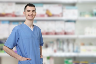 Image of Positive pharmacist in uniform at drugstore. Space for text