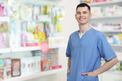 Image of Positive pharmacist in uniform at drugstore. Space for text