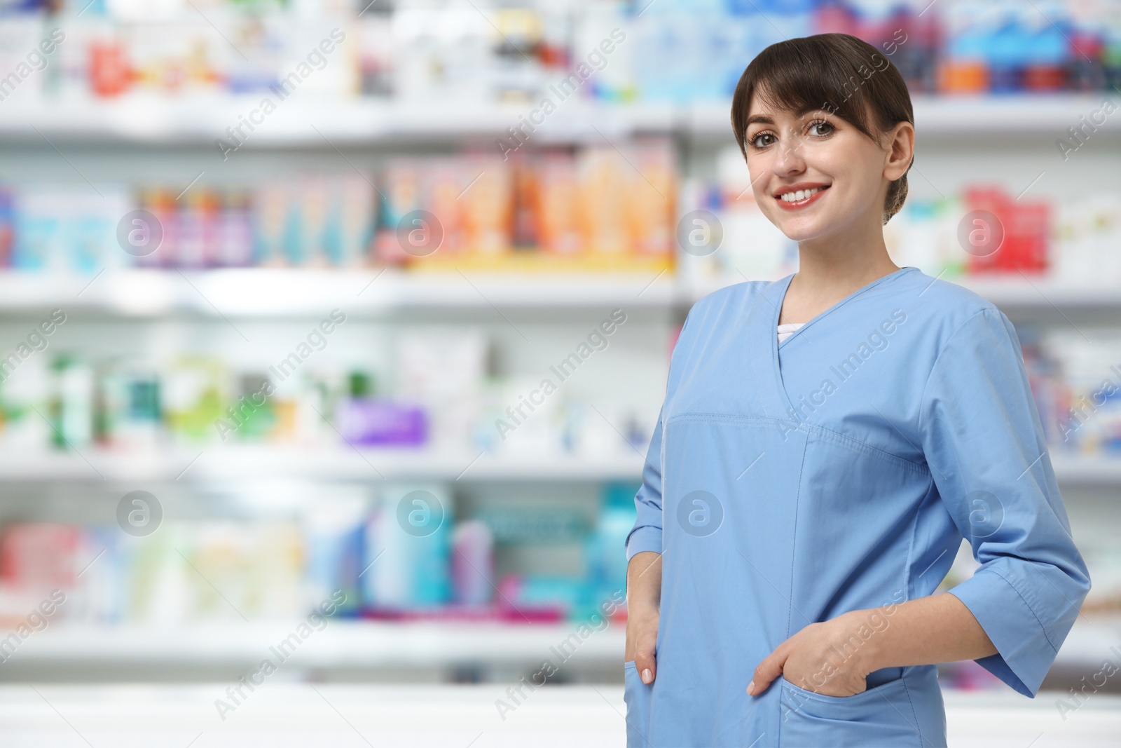 Image of Positive pharmacist in uniform at drugstore. Space for text